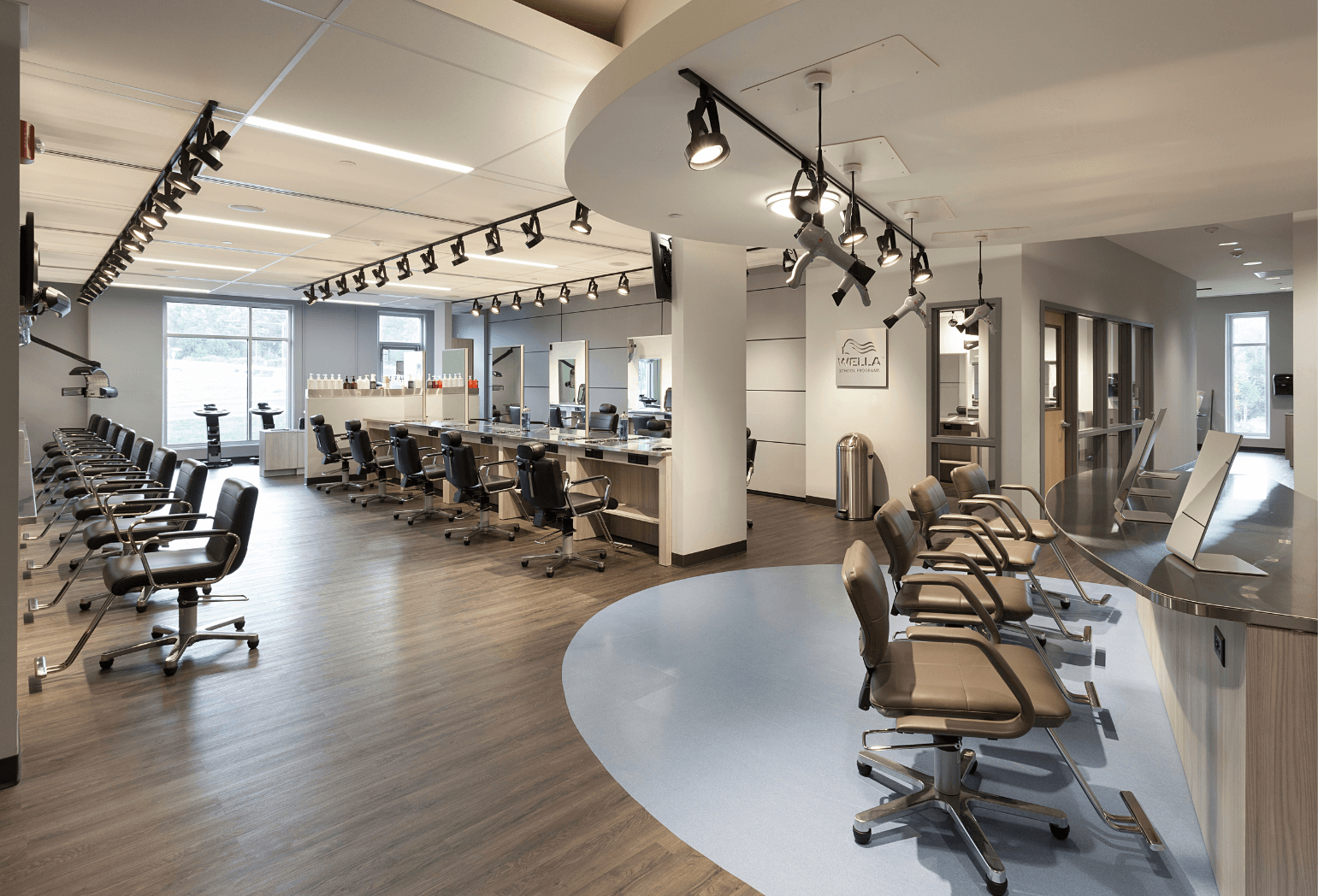 A hair salon lined with numerous chairs for customers to get their hair done in.